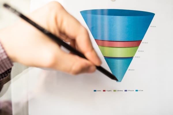 a man pinpointing the bottom of a sales funnel with his pen